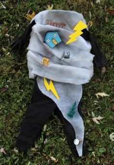 a stuffed animal is laying on the ground with its head covered in a blanket and two yellow arrows pointing towards it