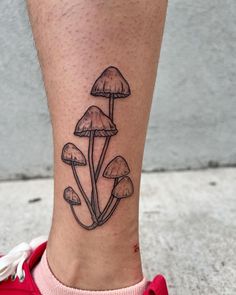 a tattoo on the leg of a person with mushrooms