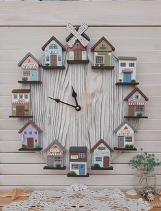 a clock made out of wooden planks with houses on the front and back sides