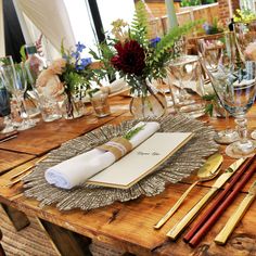 a wooden table topped with lots of place settings