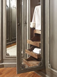 an ornate mirrored closet with drawers and towels in it's corner, is shown