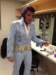 elvis presley is standing in front of a mirror