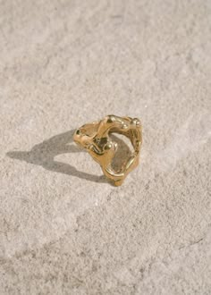 The Tecopa Ring is a bold, abstract piece inspired by the Tecopa Hot Springs in the Mojave Desert. This large ring features an open shape with a distinctive melted texture, capturing the raw and rugged beauty of its namesake. Handcrafted from an original wax carving and cast in recycled brass, the Tecopa Ring embodies modernist and brutalist design principles. Perfect for those who appreciate striking and unconventional jewelry, this piece stands out with its artistic and edgy aesthetic. Its unique design ensures it becomes a conversation starter, whether worn daily or for special occasions. Sizes 5-10. Handmade to order in Los Angeles. Please allow us time to craft the ring for you. Silver Casting Jewelry, Wax Cast Ring, Goldsmith Aesthetic, Lost Wax Ring, Organic Gold Jewelry, Wax Carving Ring, Unconventional Jewelry, Wax Carved Ring, Lost Wax Casting Jewelry