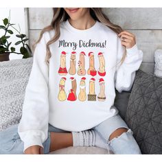 a woman sitting on a couch wearing a white sweatshirt that says merry dickenas