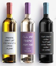 three wine bottles with labels on them sitting next to each other