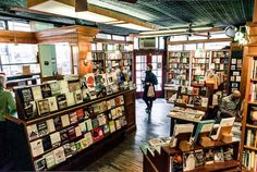 a man walking through a bookstore filled with books