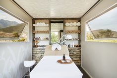 the inside of a mobile home with a table and stools in front of it