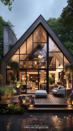 a house with an open floor plan and large windows on the front, surrounded by greenery