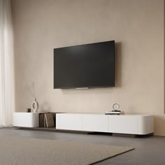 a flat screen tv mounted to the side of a white entertainment center in a living room