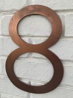 a metal number 8 on a white brick wall