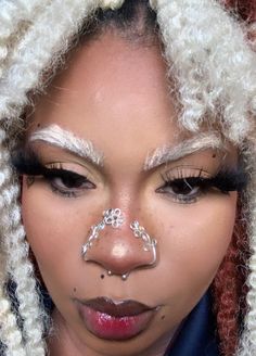 a close up of a person with white hair and piercings on her nose,