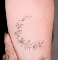 a woman's arm with a tattoo on it that has flowers in the middle