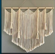 a macrame wall hanging with tassels and bells