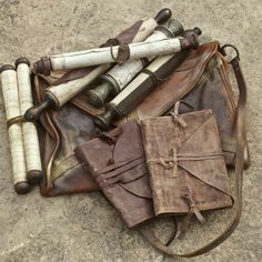 an old leather bag with rolled up baseball bats and other items sitting on the ground