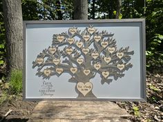 a family tree with hearts on it is displayed in front of some trees and leaves