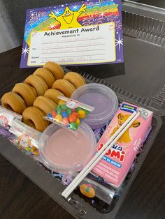 there is a plastic container with candy and other items in it that are on the table