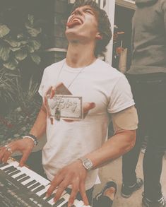 a young man is playing the keyboard outside