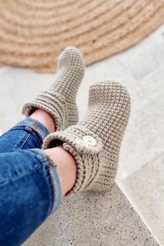 a woman's feet wearing knitted slippers with button on the front and bottom