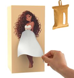 a hand holding a piece of paper next to a cutout of a woman in a white dress