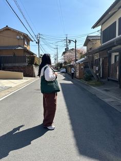 a woman standing on the side of a road