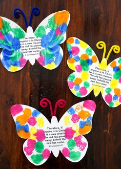 three paper butterflies with words written on them, one is colorful and the other is white