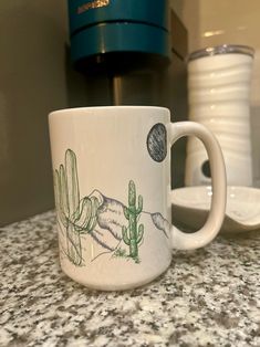 a white coffee cup sitting on top of a counter