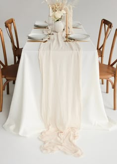 the table is set with white linens and gold place settings, including an elegant centerpiece