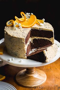 a chocolate cake with orange slices cut out on a white platter and topped with frosting