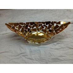 a golden bowl sitting on top of a white table