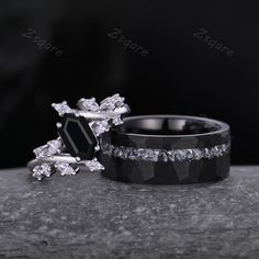 two wedding rings sitting on top of each other with black and white diamonds in them