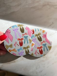 two stickers with bows on them are sitting on a counter next to a woman's hand