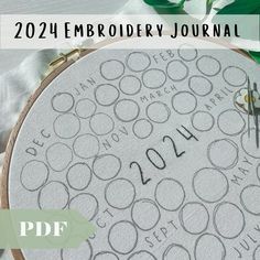 a close up of a clock on a table with text overlay that reads, 2021 embroiderer journal