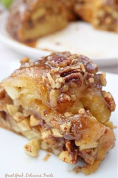 a piece of apple pie on a white plate with another slice in the back ground