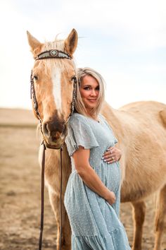 a pregnant woman standing next to a horse