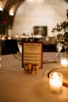 the table is set with candles, wine glasses and menus for an evening dinner