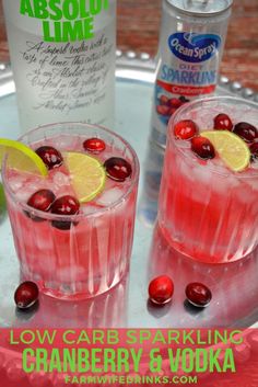 two glasses filled with cranberry vodka sitting on top of a metal tray