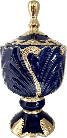 a blue and gold urn with a snake on the top, sitting in front of a white background