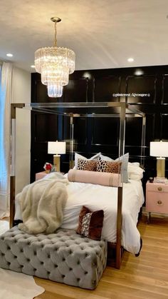 a bedroom with a large bed and chandelier