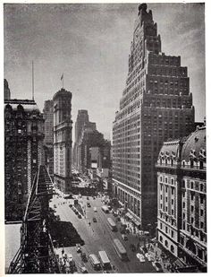 an old black and white photo of a city street with tall buildings in the background