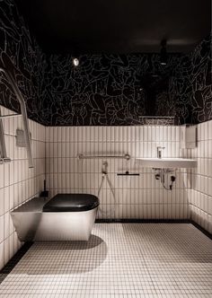 a bathroom with black and white tiles on the walls