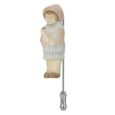 a white and pink figurine holding a baby on a metal pole with a hook