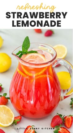 a pitcher filled with strawberry lemonade sitting on top of a table next to sliced strawberries