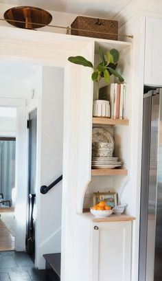 a kitchen with white walls and open shelving