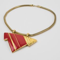 Lovely Lanvin Paris modernist pendant choker necklace. Serpentine gilt metal chain ornates with geometric pendant in shiny gilt metal and red enamel. Spring ring-closing clasp. Signed with a little gilded tag underside the pendant: "Lanvin - Paris." Measurements: total length 15.38 in (39 cm) - pendant: 2.88 in wide x 2.38 in high (7.3 x 6 cm).  Please see the measurements noted above, in the description for the best approximate dimensions. Red Metal Necklace With Large Pendant, Formal Red Enamel Necklaces, Formal Red Enamel Necklace, Red Enamel Jewelry With Large Pendant, Retro Red Metal Jewelry, Red Retro Metal Jewelry, Modernist Enamel Jewelry For Gifts, Modernist Enamel Jewelry Gift, Modern Red Metal Jewelry