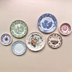 six plates with different designs on them are lined up in a row and one is empty