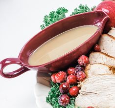 a white plate topped with sliced turkey next to an apple and cranberry sauce