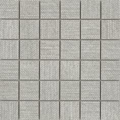 a gray and white tiled wall with squares