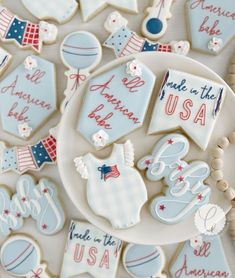 decorated cookies are displayed on a plate in the shape of flags, stars and pennants