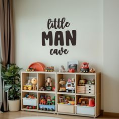 a child's playroom with toys and wall decal that says, little man cave