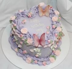 a birthday cake decorated with flowers and butterflies